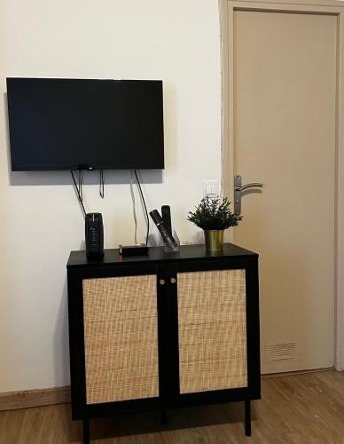 un meuble TV noir avec un écran plat fixé au mur dans l'établissement Montparnasse, à Paris