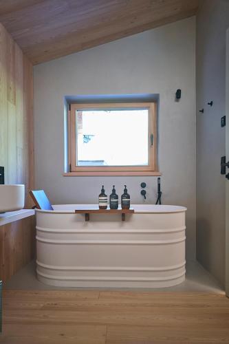 a bath tub in a bathroom with a window at Eagle & Marmot, Carezza Dolomites in Carezza al Lago