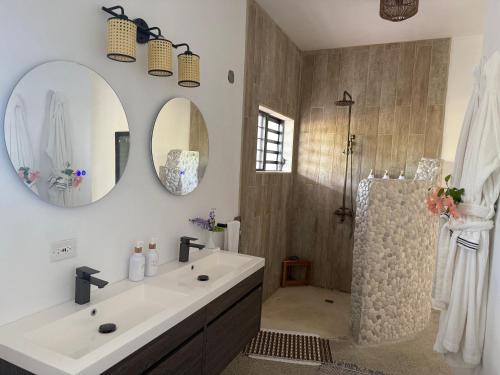a bathroom with a white sink and a shower at Egret at Galley Bay View in Five Islands Village