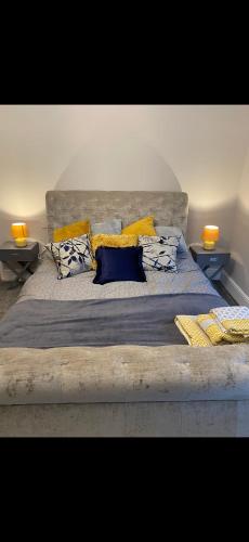 a large bed with yellow and blue pillows on it at Cambridge Villa St Annes in Lytham St Annes