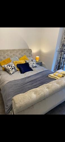 a large bed with yellow pillows on top of it at Cambridge Villa St Annes in Lytham St Annes