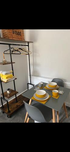 a table with yellow plates on it in a room at Cambridge Villa St Annes in Lytham St Annes