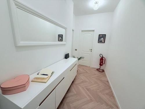 a white room with a desk and a pink stool at WANDERLUST Splendido appartamento in centro in Pavia