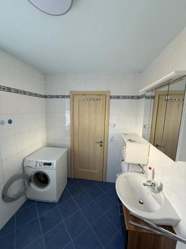 a bathroom with a washing machine and a sink at Ferienwohnung Pipflhof in Wattens