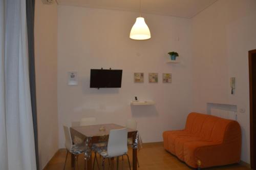ein Wohnzimmer mit einem Tisch und einem orangefarbenen Sofa in der Unterkunft Arió Sweet Home in Neapel