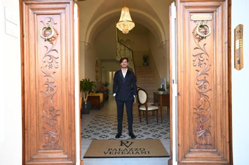 a man in a suit standing in a doorway at Palazzo Veneziani - Luxury Living in Monopoli in Monopoli