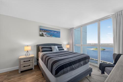 a bedroom with a bed and a large window at Luxe Stay Water & City View in Downtown Ft Myers in Fort Myers