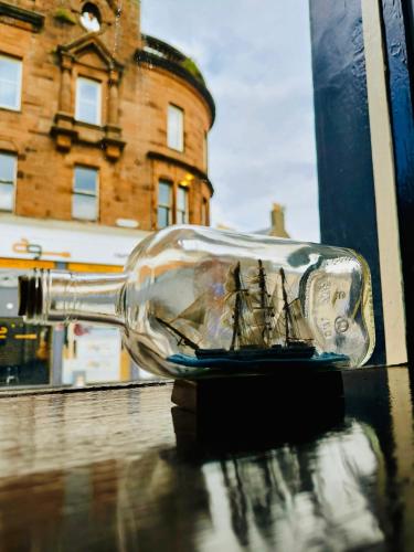a bottle with a ship in it sitting on a table at The Ayrshire and Galloway in Ayr