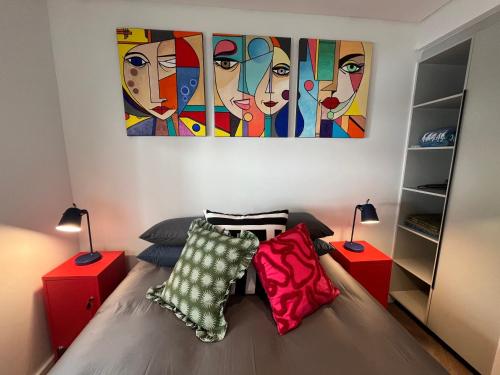 a bedroom with a bed with a painting on the wall at The Happy Chameleon in George