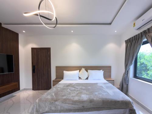 a bedroom with a large bed and a chandelier at Executive Cozy Suite at THE HIDDEN DOMUS I Saltpond Suite in Madina
