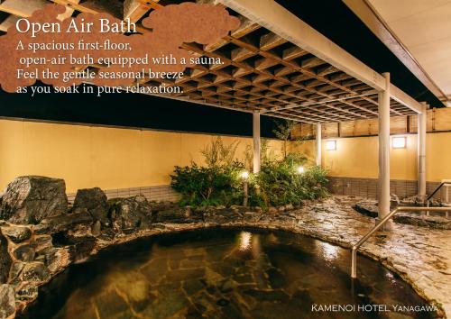 an open air bath in a building with a pool of water at KAMENOI HOTEL Yanagawa in Yanagawa