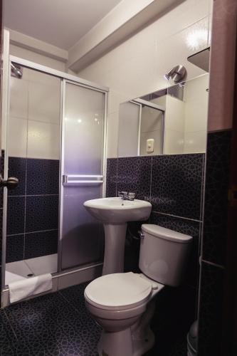 a bathroom with a toilet and a sink and a shower at Hotel Plaza Bolognesi 344 in Trujillo