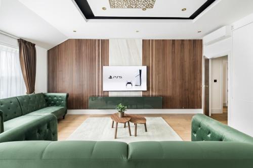 a living room with green couches and a table at LONDONERS - Marylebone Serviced Apartments in London