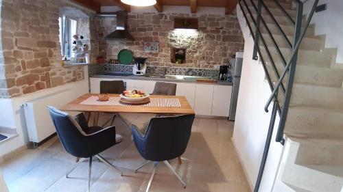 a small kitchen with a wooden table and chairs at Casa Bumbara in Vodnjan