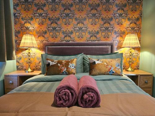 a bedroom with a bed with towels on it at StayZen Apartments - Luxury Central Apartment with Parking - sleeps 8 in Woking