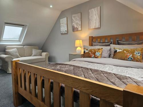 a bedroom with a large bed and a couch at StayZen Apartments - Luxury Central Apartment with Parking - sleeps 8 in Woking