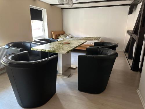 a dining room with a table and black chairs at Diah's Apartment in BEUERN - für Monteure in Felsberg