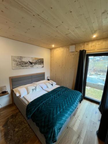 a bedroom with a large bed with a large window at Saalach Chalet in Lofer