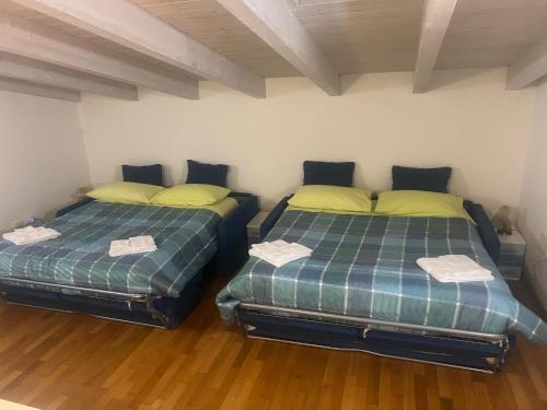 two twin beds in a room with wooden floors at Midnight sun pomposa lido in Lido di Pomposa
