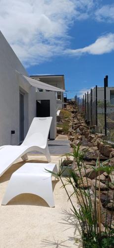 a white bench sitting in front of a house at Anima Lodge in Villa Carlos Paz