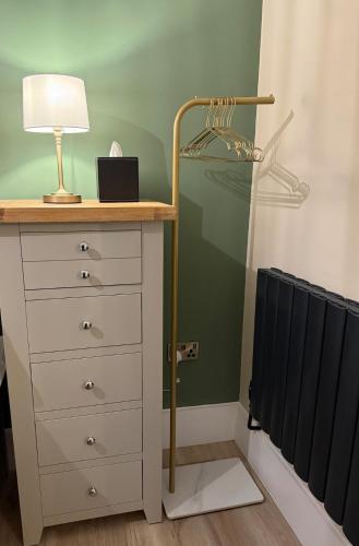 a bedroom with a dresser with a lamp and a mirror at Townhouse in Shaftesbury