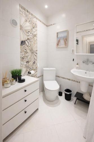 a white bathroom with a toilet and a sink at Apartmán na Žerotínce in Šumperk
