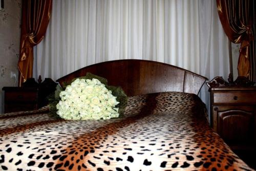 un dormitorio con una cama con un ramo de flores en Apartment On Prospekt Kirova, en Dnipro