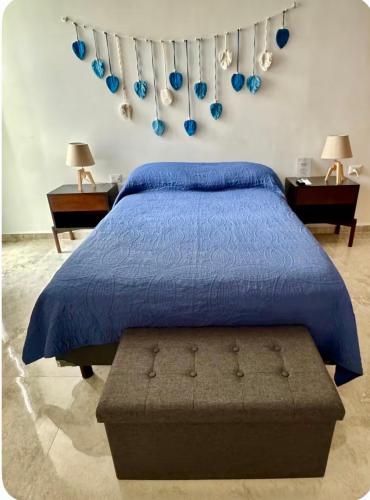 a bedroom with a bed with a blue comforter at Departamento en Mérida en Privada con Amenidades in Xcanatún