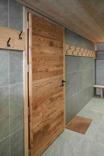 a wooden door in a bathroom with a shower at Beautiful chalet with views in Montgenèvre