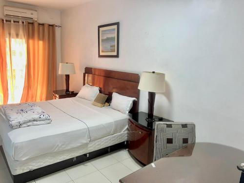 a bedroom with a bed and a desk with two lamps at Amsy hotel in Dakar