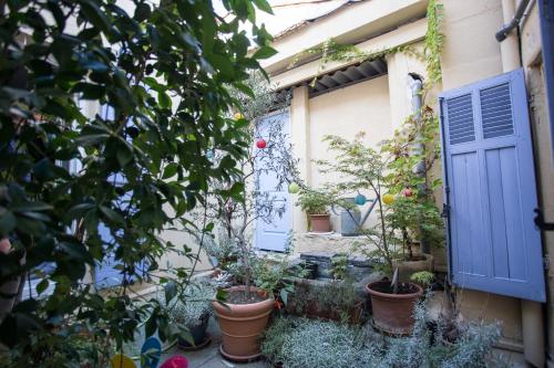 a garden with potted plants and a blue door at Logis hôtel du terreau in Manosque