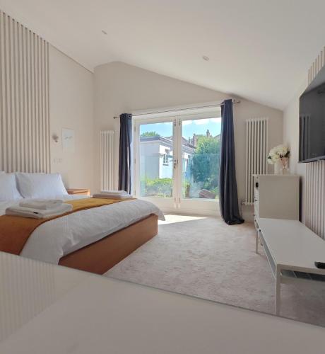 a bedroom with a large bed and a large window at The Windsor Courtyard in Windsor