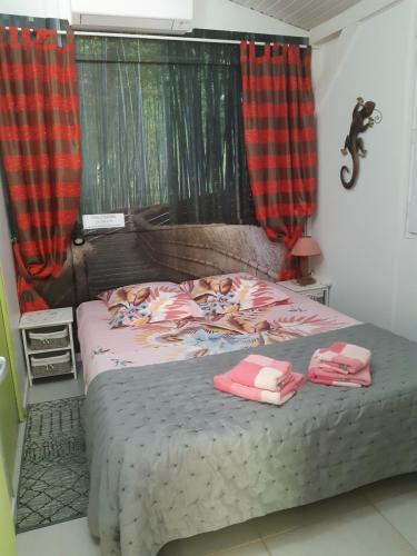 a bedroom with a bed with two towels on it at Gîte HIBISCUS in Saint-François