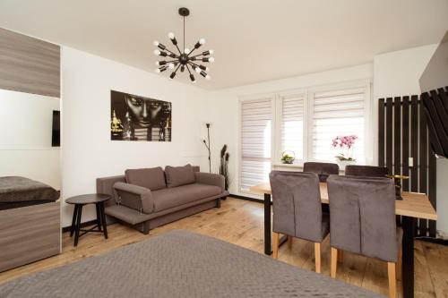 a living room with a couch and a table at Kolbi Signature Platinum Residence in Białogard