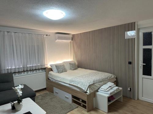 a small bedroom with a bed and a chair at Studio Apartman Karlo in Zaprešić