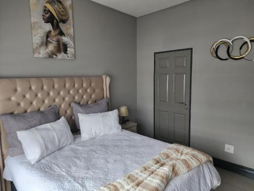 a bedroom with a bed with a tufted headboard at Leaf Mbabane CBD Apartment in Mbabane