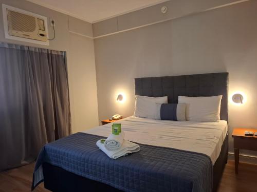 a hotel room with a bed with a towel on it at Flat Borges Lagoa Vl Mariana Ibirapuera com garagem UH1007 in São Paulo