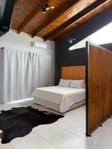 a bedroom with a bed with a wooden headboard at Complejo La Conquista in Goya