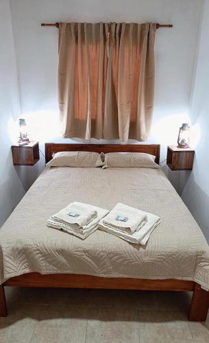 a bedroom with a bed with two towels on it at Mi sueño apart en Mercedes Corrientes!!! in Mercedes