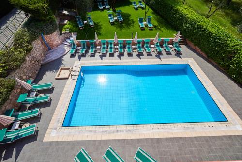 an overhead view of a large swimming pool with lounge chairs and sidx sidx at Residence Hotel Vacanze 2000 - Adults Only in Malcesine
