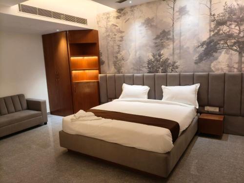 a bedroom with a large bed and a couch at Hotel The Paradise in Bihār Sharīf
