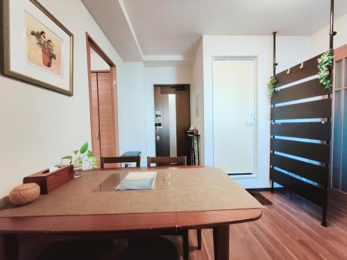 a dining room with a wooden table and a staircase at Sun Hotel in Tokyo