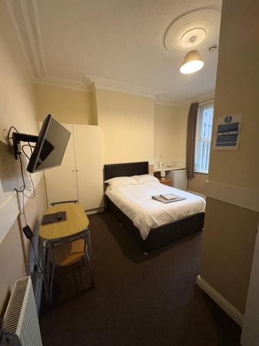 a hotel room with a bed and a television at Runcorn Jubilee Guest House in Runcorn