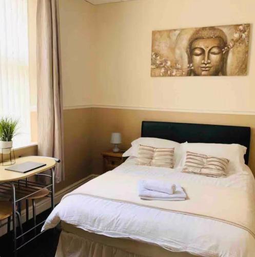 a bedroom with a bed with a statue on the wall at Runcorn Jubilee Guest House in Runcorn