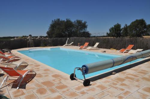a swimming pool with lounge chairs and a swimming pool at Les Gîtes De La Chérine in Quinson