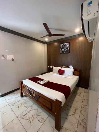 a bedroom with a large bed with a ceiling fan at Serenity Sunrise Beach Resort in Pondicherry