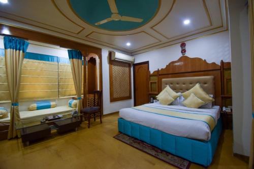a bedroom with a large bed and a room with a window at Hotel Royal Embassy in Bhilwara
