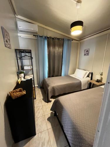a room with two beds and a table with a shelf at Elia’s house in Ligia