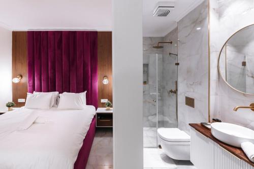 a bedroom with a king sized bed and a bathroom at מילה בוטיק - סוויטה מהממת עם 2 חדרי שינה, מתחם מקורה עם בריכה מחוממת, ג'קוזי ספא וסאונה! in ‘Ein Ya‘aqov