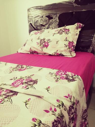 a bed with a pink and white comforter and pillows at Dar-Dhiafa Mayar in Mahdia
